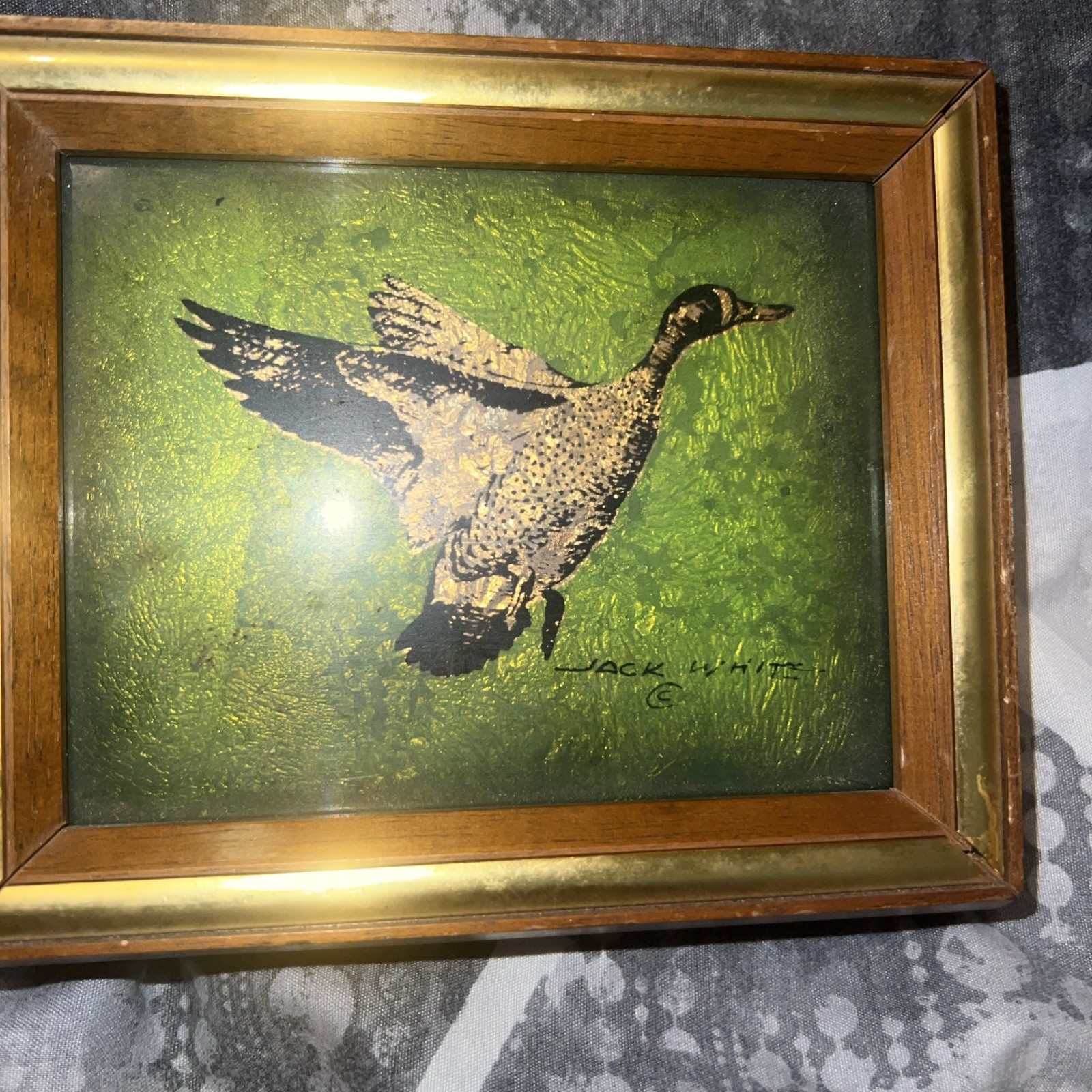 A painting by Jack White, which utilizes a gold leaf process applied to glass.